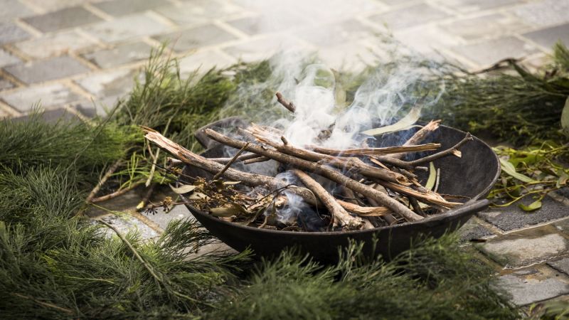 Leaves smoking in small fire on a stove pavement