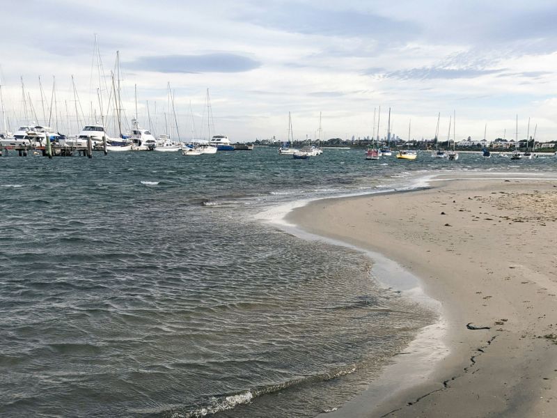 Melbourne beach with boats floating in the background